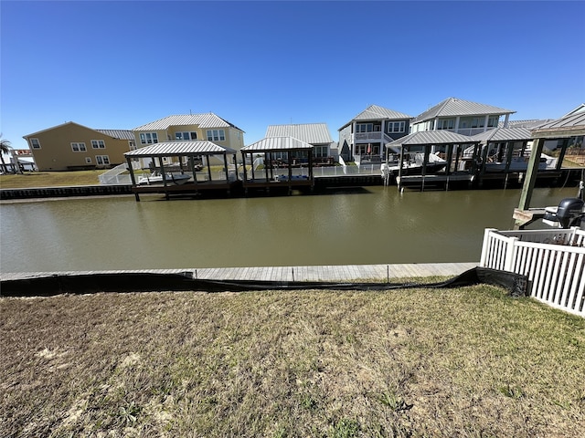 view of dock with a gazebo, a yard, and a water view