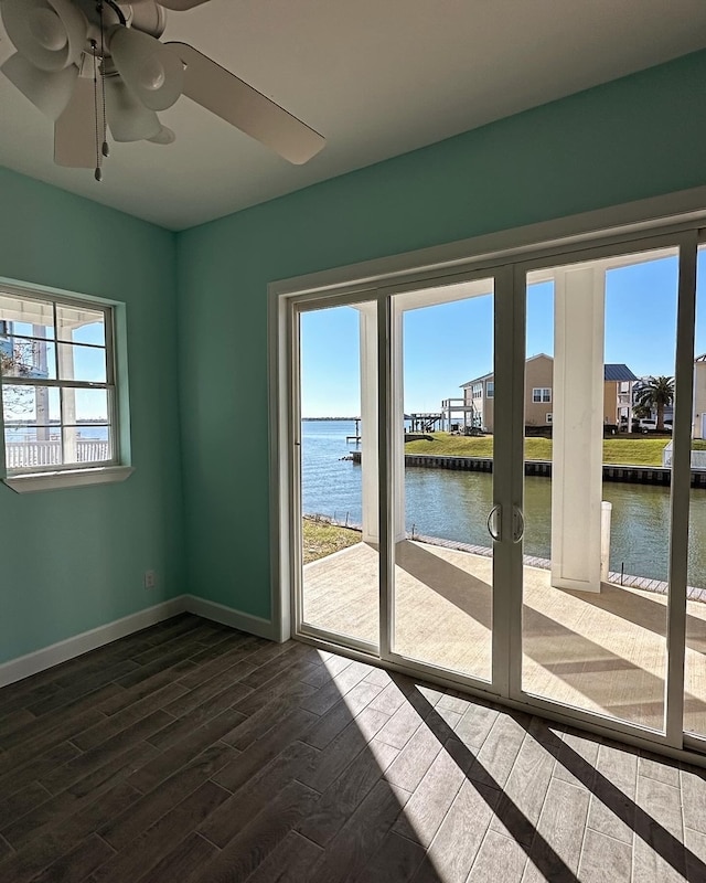 spare room featuring french doors, a water view, ceiling fan, and hardwood / wood-style floors