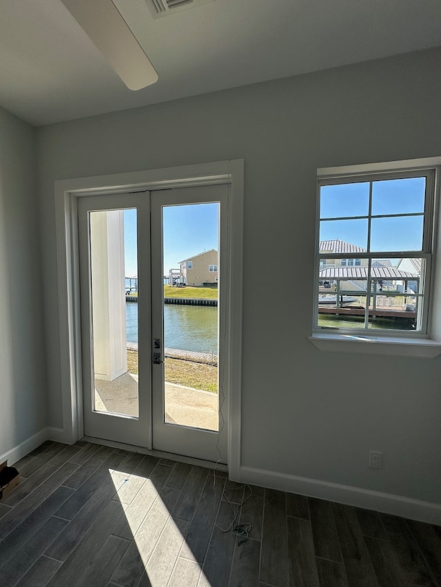 doorway to outside with a water view, dark hardwood / wood-style floors, plenty of natural light, and french doors