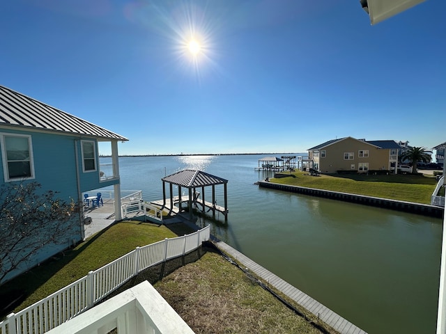 view of dock with a lawn and a water view