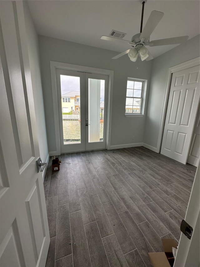 empty room featuring ceiling fan, french doors, and dark hardwood / wood-style flooring