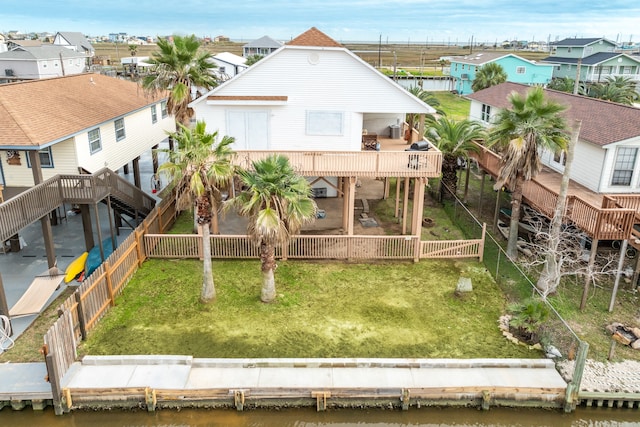 rear view of house featuring a yard and a deck with water view