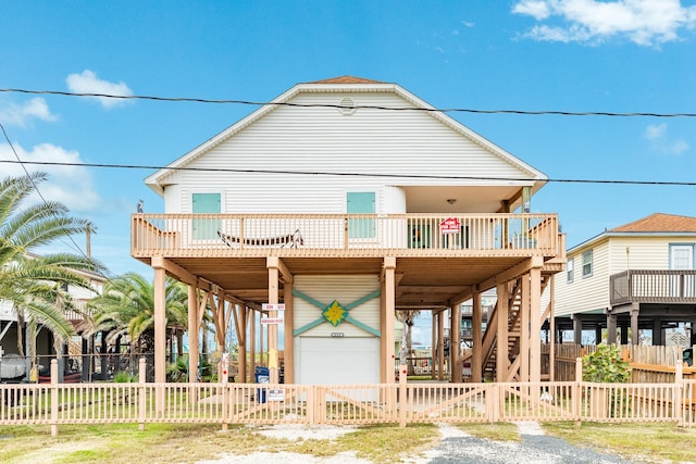 view of front of home with a garage, a balcony, a fenced front yard, a gate, and a carport