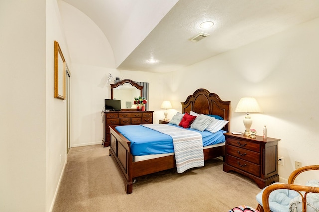 bedroom with light carpet, vaulted ceiling, visible vents, and baseboards