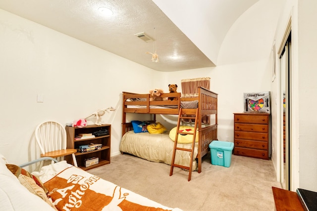 bedroom featuring visible vents and light carpet