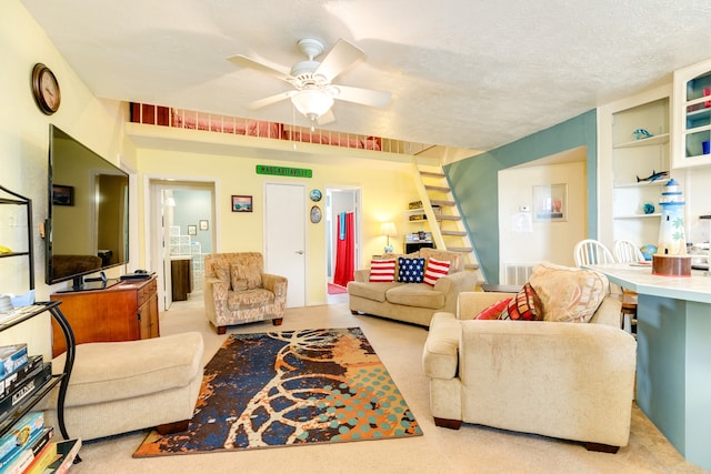 living room with light carpet, ceiling fan, and a textured ceiling