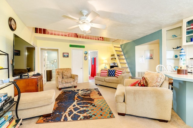 living room with built in features, light carpet, a textured ceiling, and a ceiling fan