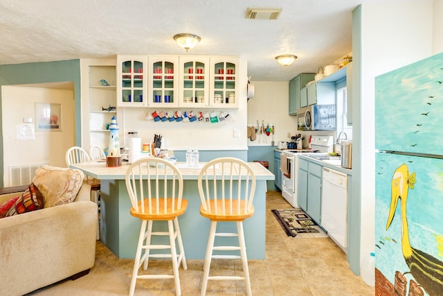 kitchen with white appliances, visible vents, open shelves, and light countertops