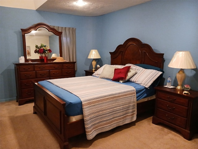 bedroom with light colored carpet and a textured ceiling