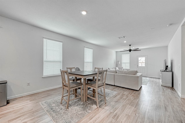 dining area with light hardwood / wood-style floors and ceiling fan