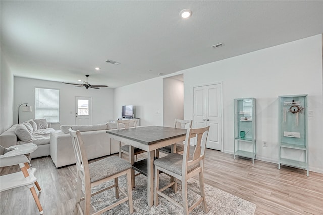 dining space with light wood-type flooring and ceiling fan