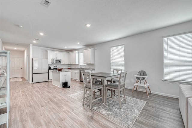 dining space featuring light hardwood / wood-style flooring and a healthy amount of sunlight