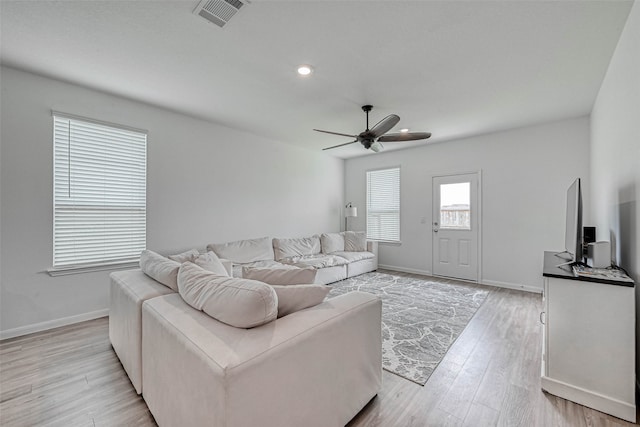 living room featuring light hardwood / wood-style floors and ceiling fan