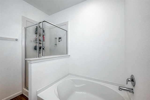 bathroom with independent shower and bath and hardwood / wood-style floors