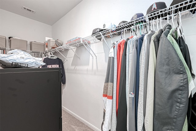 walk in closet featuring carpet flooring