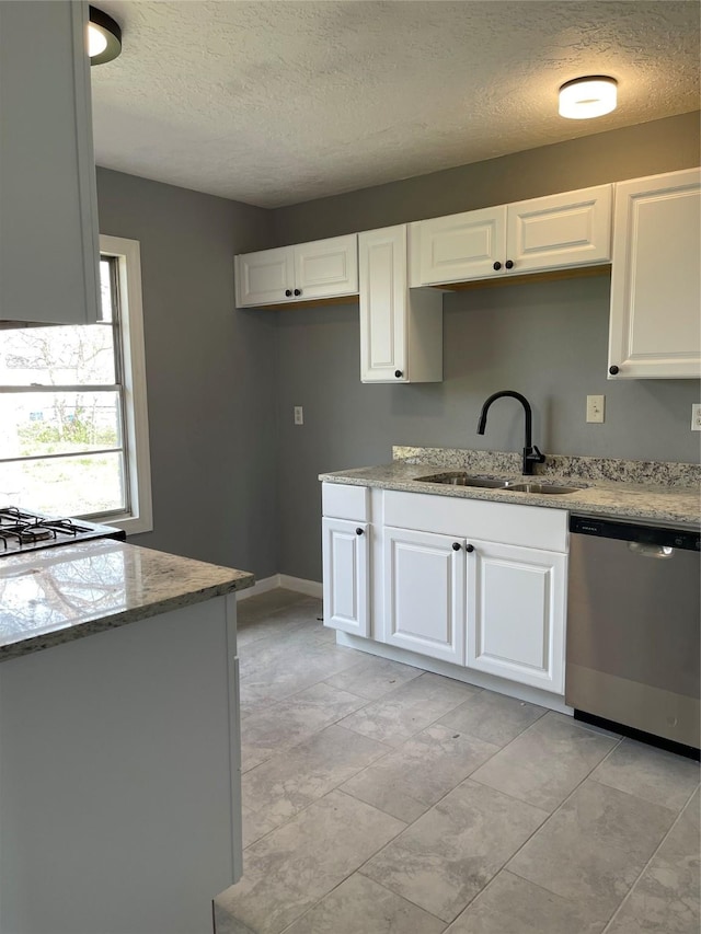 kitchen featuring dishwasher, light stone counters, white cabinetry, and sink