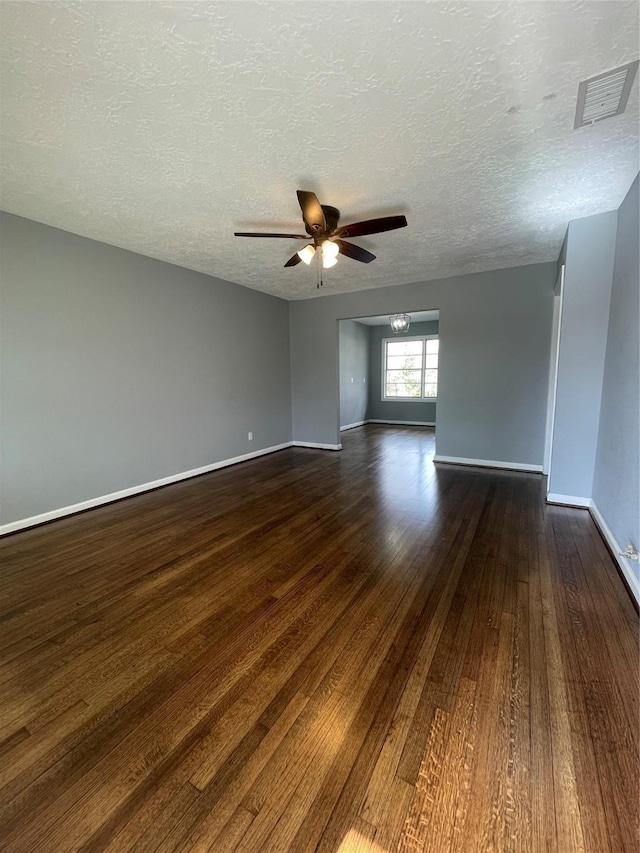 spare room with a textured ceiling, ceiling fan, and dark hardwood / wood-style floors