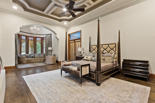 bedroom with beam ceiling, coffered ceiling, crown molding, hardwood / wood-style floors, and ceiling fan with notable chandelier