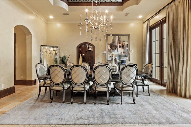 dining area with a raised ceiling, ornamental molding, and an inviting chandelier