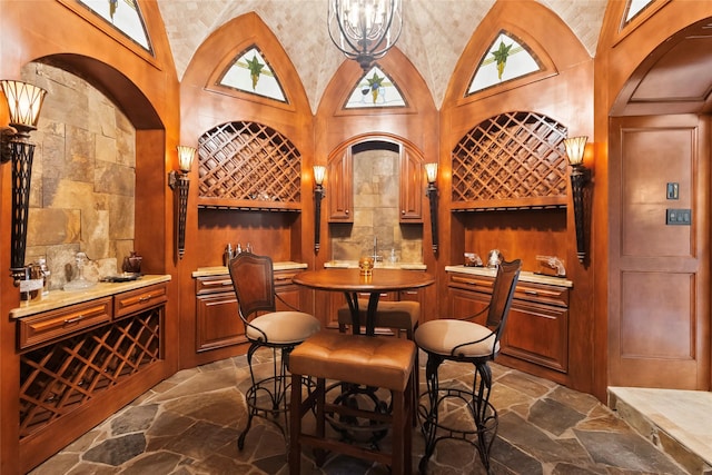 wine cellar featuring high vaulted ceiling and bar area