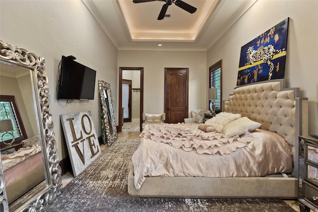 bedroom featuring a raised ceiling, ceiling fan, and crown molding