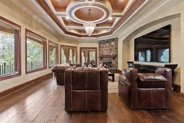 living room featuring ornamental molding, coffered ceiling, dark wood-type flooring, a notable chandelier, and a fireplace