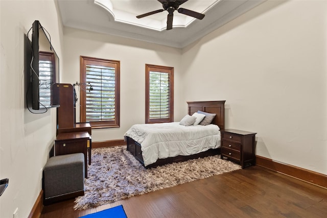 bedroom featuring dark hardwood / wood-style flooring, ceiling fan, and ornamental molding