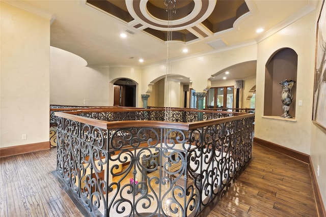 corridor featuring dark hardwood / wood-style floors, crown molding, and coffered ceiling