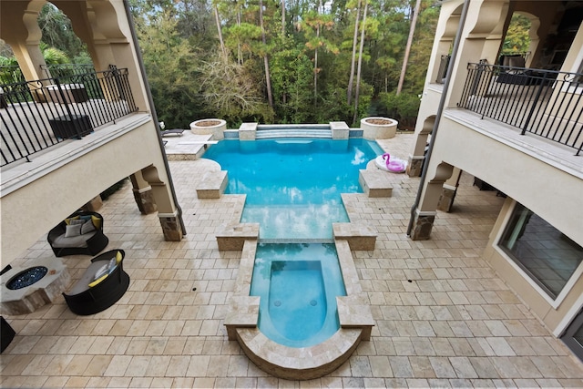 view of pool featuring a patio area and an in ground hot tub