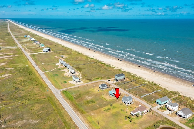 birds eye view of property featuring a water view and a beach view