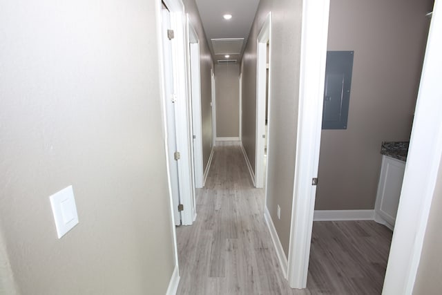 corridor featuring light wood-type flooring and electric panel