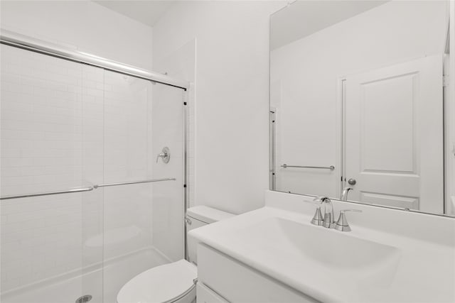 bathroom with an enclosed shower, vanity, and toilet