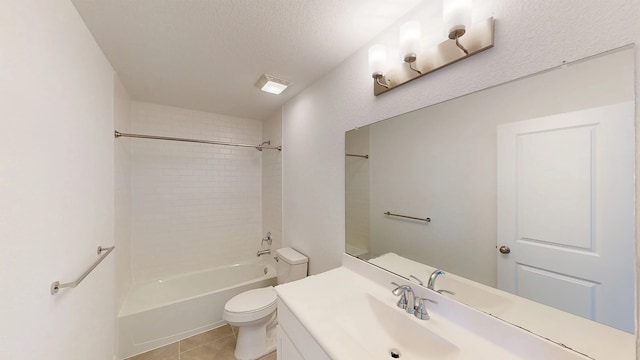 full bathroom with vanity, tile patterned flooring, a textured ceiling, tiled shower / bath, and toilet