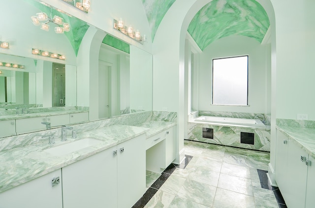 bathroom with a relaxing tiled bath, tile flooring, large vanity, and an inviting chandelier