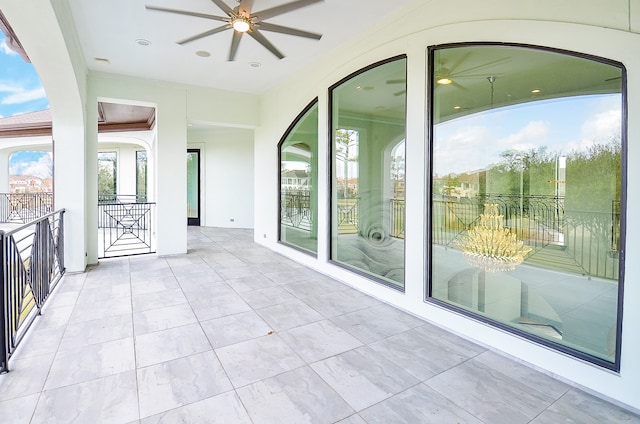 unfurnished sunroom featuring ceiling fan with notable chandelier