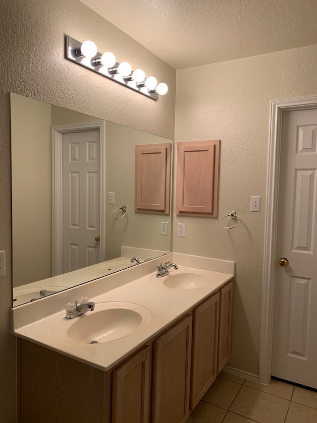 bathroom featuring double sink vanity, tile floors, and a textured ceiling