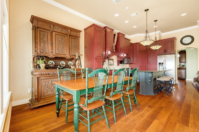 dining space with ornamental molding and hardwood / wood-style floors