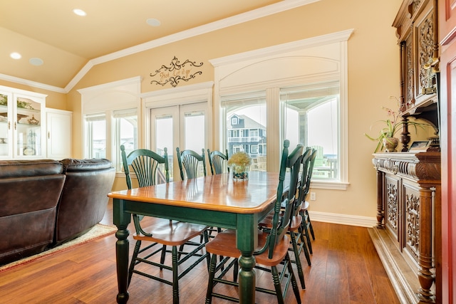 dining area featuring french doors, ornamental molding, vaulted ceiling, and dark wood-type flooring