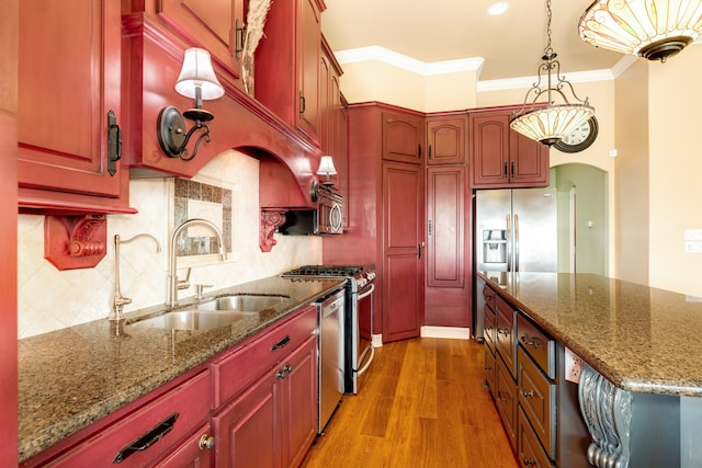 kitchen featuring pendant lighting, light stone counters, crown molding, backsplash, and light hardwood / wood-style floors