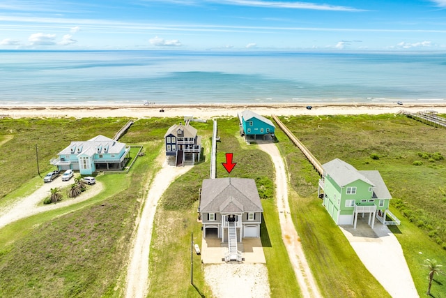 drone / aerial view featuring a water view and a view of the beach