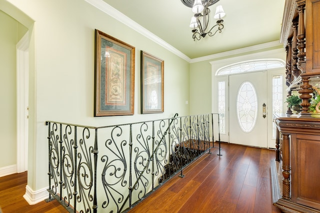 entrance foyer featuring a chandelier, ornamental molding, and dark hardwood / wood-style floors