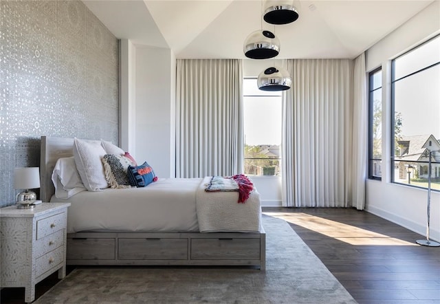 bedroom featuring multiple windows, lofted ceiling, and dark hardwood / wood-style floors