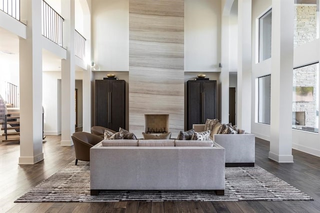 living room with a high ceiling and dark hardwood / wood-style floors