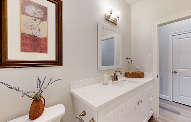 bathroom featuring hardwood / wood-style flooring, toilet, and vanity