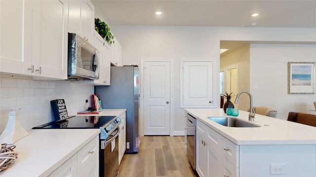 kitchen featuring sink, stainless steel appliances, light wood-type flooring, and white cabinetry