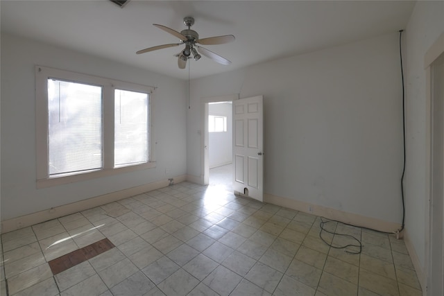 tiled spare room with ceiling fan