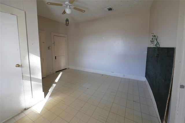 tiled spare room featuring ceiling fan