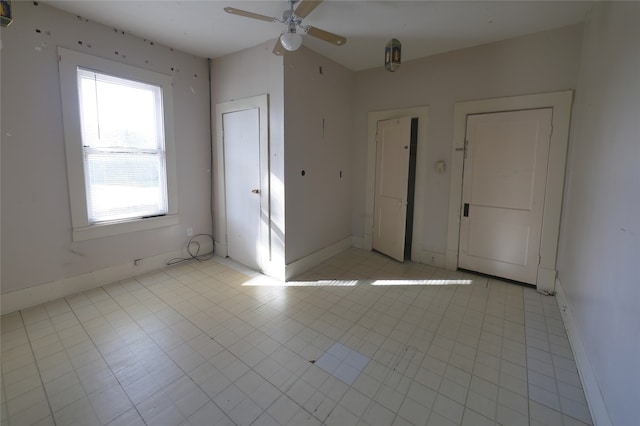 unfurnished bedroom with light tile patterned flooring and ceiling fan