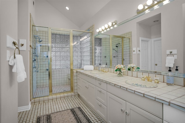 bathroom with walk in shower, tile patterned flooring, lofted ceiling, and vanity