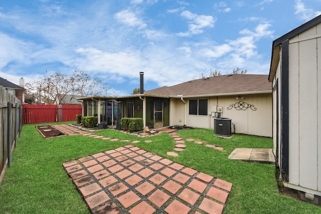 rear view of property with central air condition unit, a sunroom, a yard, and a patio